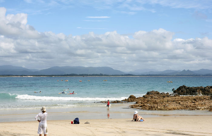 Bayron Bay beach during the day with surfers and beach goers